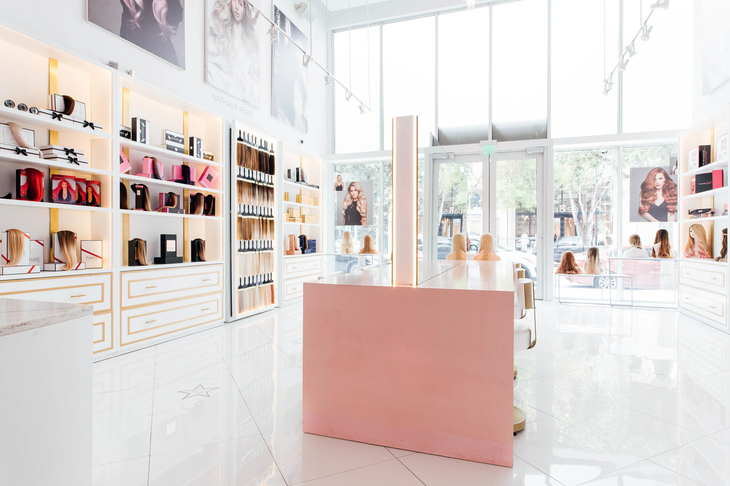 Bright, modern hair extension salon interior with product displays, mannequin wigs, and large windows with natural light.